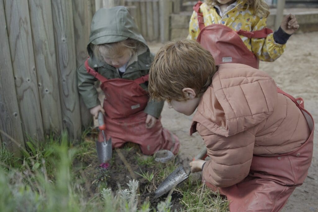 Two young boys planting bumblebee-friendly flowers.