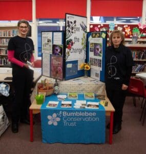 Two people in front of a stall with bumblebee leaflets