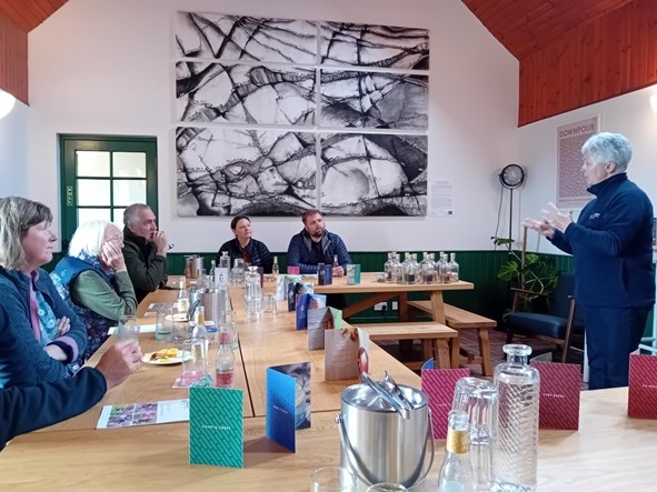 Group of people around a table listening to a presenter